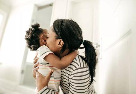 Mother hugging toddler.