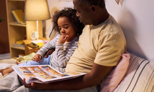 Caregiver reading a bedtime story with young child