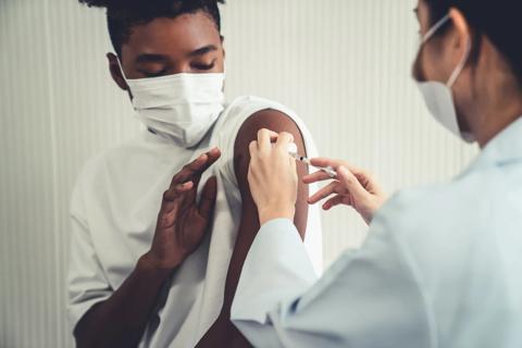 Young man receiving injection with hesitation