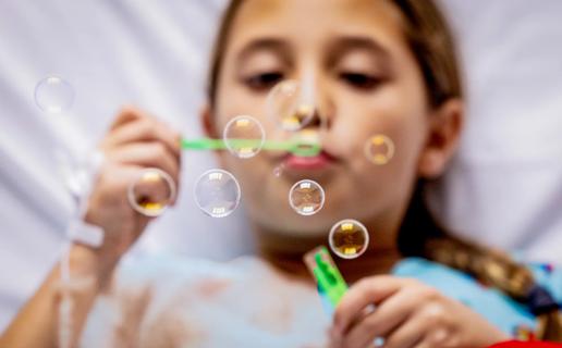 Hospitalized child blowing bubbles