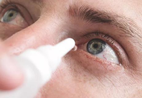woman washing out eye with drops