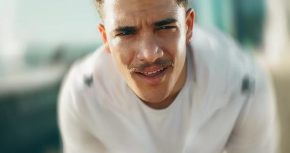 Person sweating, bent over, grimacing