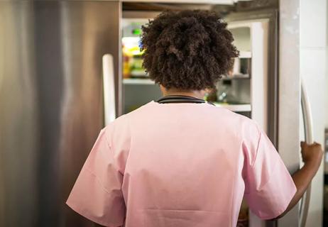 Person opening a refrigerator door and looking inside