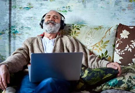 Older man happily relaxing and listening to music