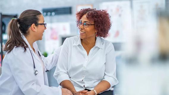 smiling healthcare provider speaking with smiling patient