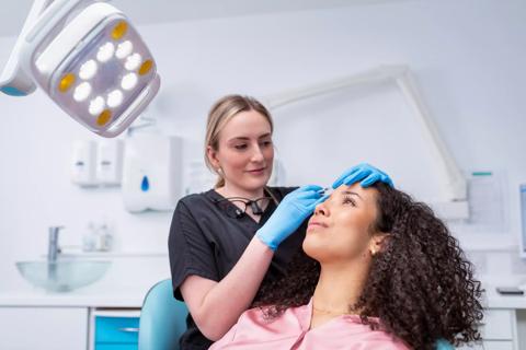 Younger person getting a botox injection in forehead from healthcare professional