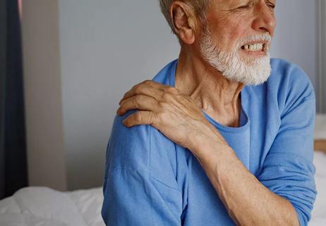 man with shoulder pain in bedroom