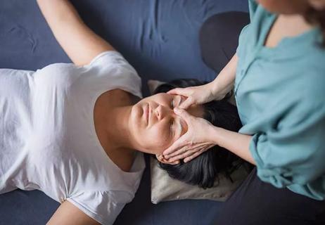 person getting a sinus massage between brows