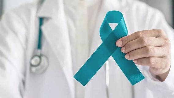 Teal awareness ribbon in doctor's hand, symbolic bow color for supporting patient with PCOS