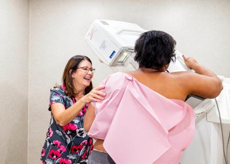 Smiling healthcare provider helping female get a mammogram