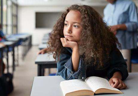 Adolescent girl disaffected holding book in class