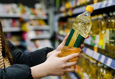 person at grocery store reading oil label