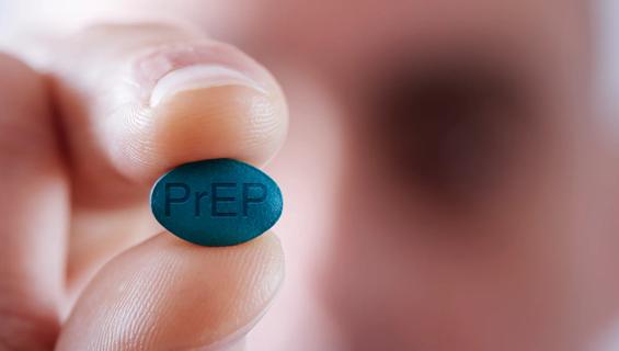 Hand holding blue PrEP pill