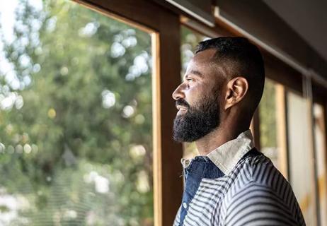 Middle-aged man looking out window.