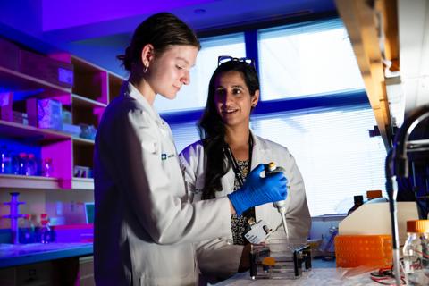 Dr. Sharma speaks with colleague in the lab
