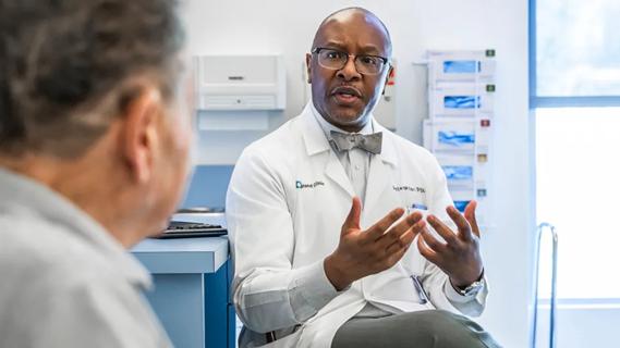 Dr. Dylan Wint talking to a patient in a medical office