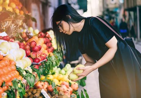 Woman shops at market for pears and apples