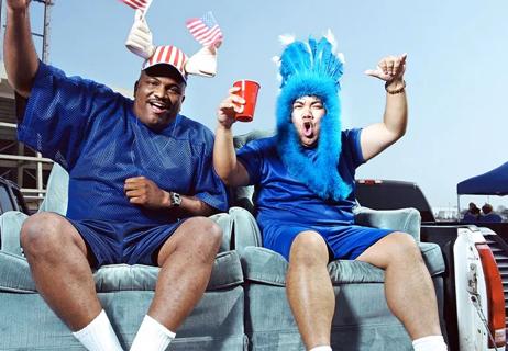 Sports Fans in back of pickup dressed up in costumes on game day drinking alchohol.