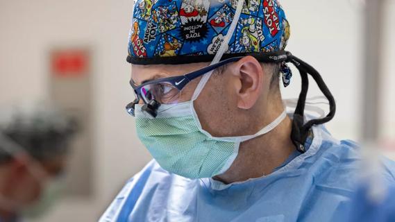 Surgeon wearing a surgical cap and mask