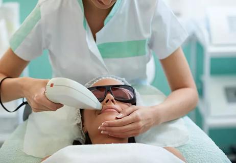 A person receiving a medical skin treatment above their lips at a doctor's office