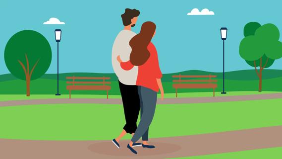 Couple walking in park with arms around each other