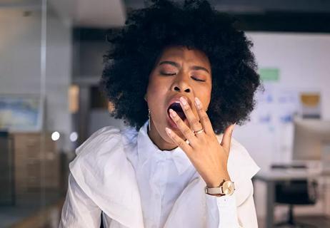 Person at office yawning at desk.