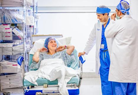 Medical team pushing hospital bed down corridor