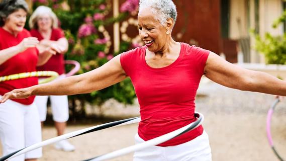 Elderly woman dances and exercises with her friends