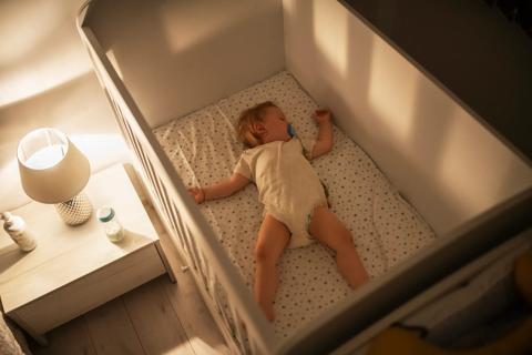 Baby sleeping on their back in crib