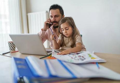 Dad looks stressed while working from home with child during COVID-19 pandemic