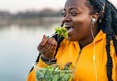 Person eating kale salad with chickpeas, natural source of manganese.