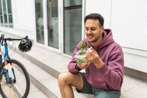 Person taking a break from bike riding, eating a salad