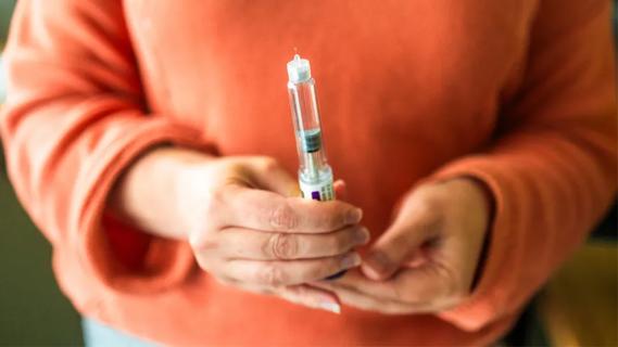 Woman's hands holding drug injector