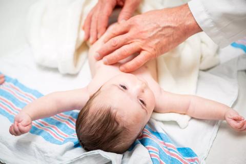 Doctor examining infant's belly