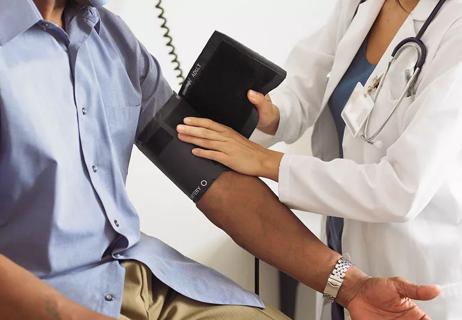 man having blood pressure checked in doctor's office
