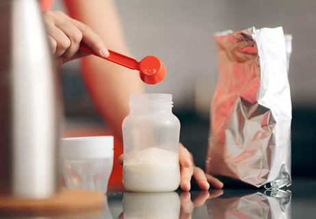 mother making baby formula in bottle