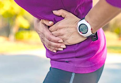 woman having side cramps during workout