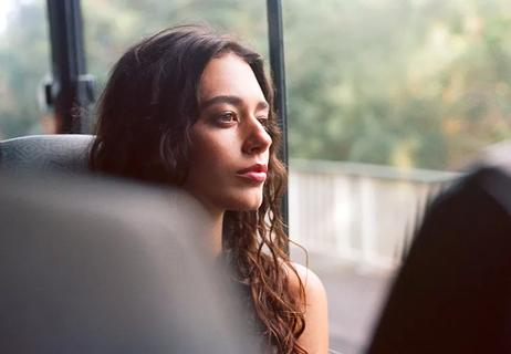 A young woman stares serenely out the window