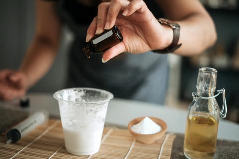Person mixing baking soda and apple cider vinegar to make a home remedy