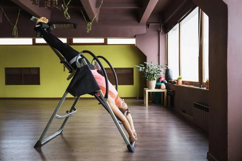 Person upside down on an inversion table during inversion therapy