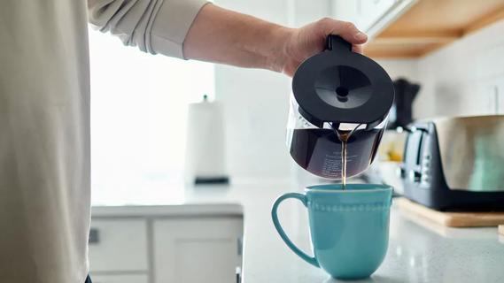 Close up of person pouring a cup of coffee