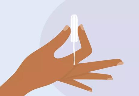 A hand holding a tampon without an applicator.