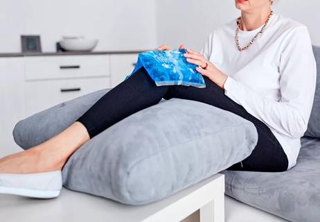 Woman icing and elevating her hurting knee