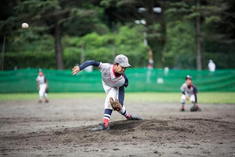 Young child in uniform pitches baseball during game