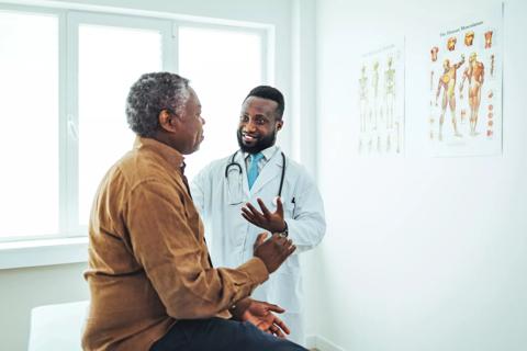 Healthcare provider consulting with male patient in exam room