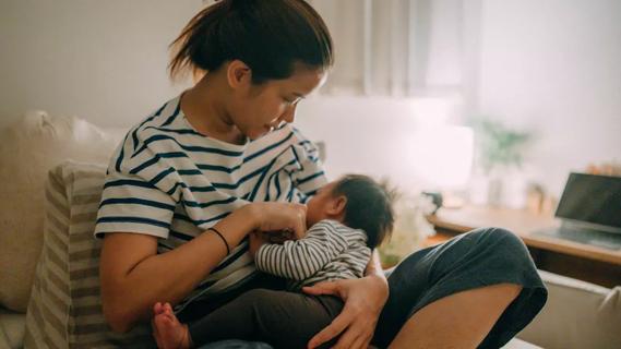 Woman in chair breastfeeding an infant