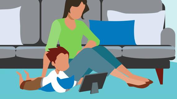 Caregiver sitting with child while they're getting screen time on a tablet