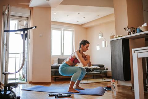 Person doing squats on mat at home