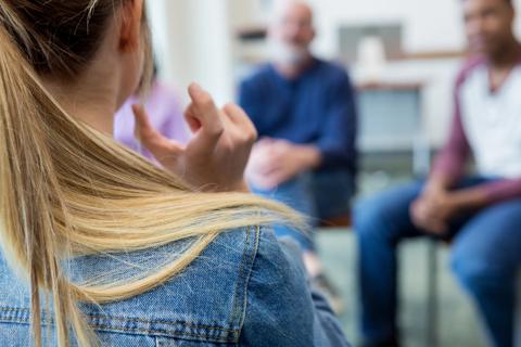 Young woman talking with others in a circle