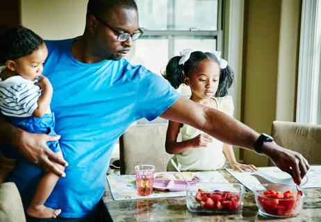 Man serving a healthy breakfast to his two children